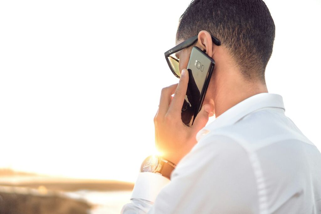 Person mit Smartphone als Symbolbild für Googles Call-for-Me-Funktion