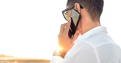 Person mit Smartphone als Symbolbild für Googles Call-for-Me-Funktion