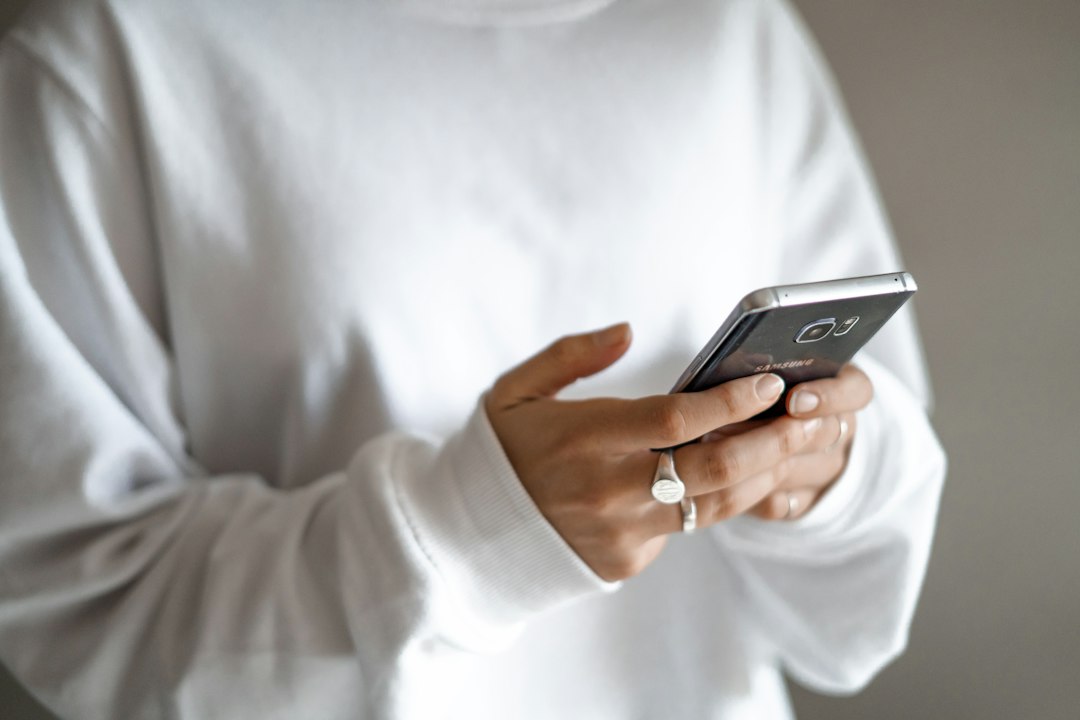 Person mit Smartphone als Symbolbild für automatisierte Anrufe