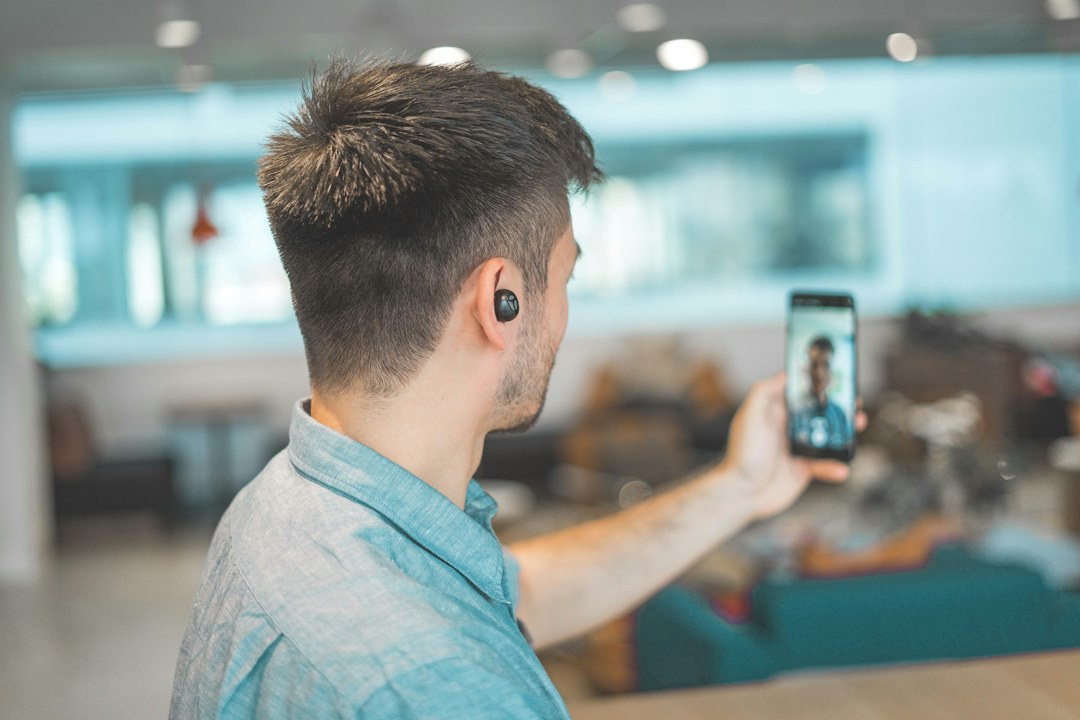Person nutzt die Frontkamera eines Smartphones