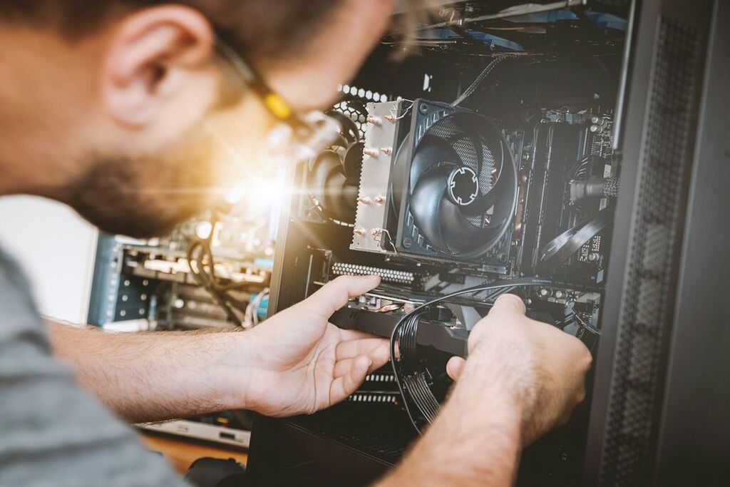 Person beim Einbau einer Grafikkarte als Symbolbild für Treiber- und Hardwarekonflikte