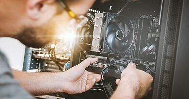 Person beim Einbau einer Grafikkarte als Symbolbild für Treiber- und Hardwarekonflikte