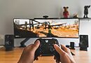 Person mit Gamecontroller als Symbol für PC- und Konsolenspiele