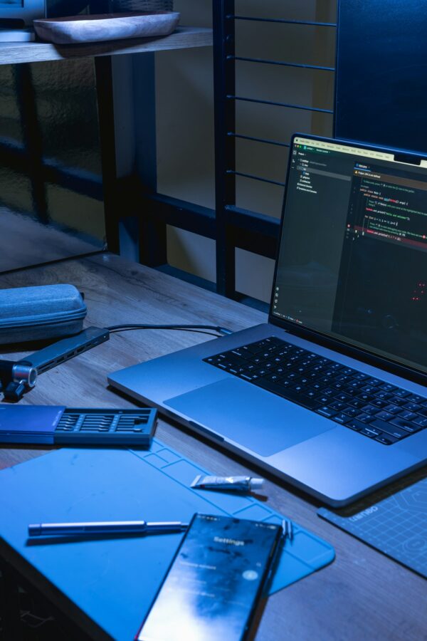 Laptop und Smartphone auf einem Schreibtisch, Symbolbild für mobile Technik