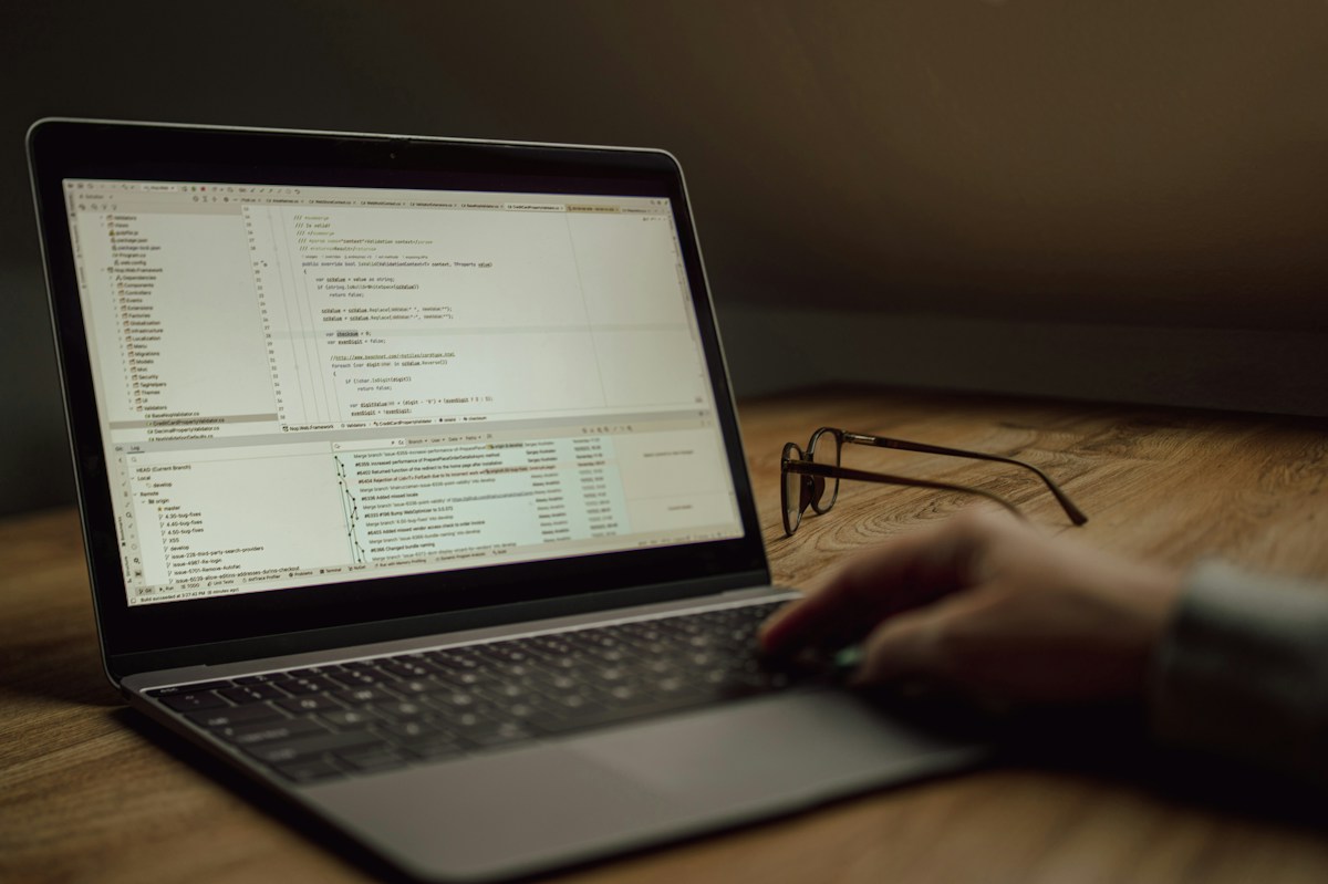 Person arbeitet an einem Laptop mit Programmcode, Symbolbild für Kontenverwaltung